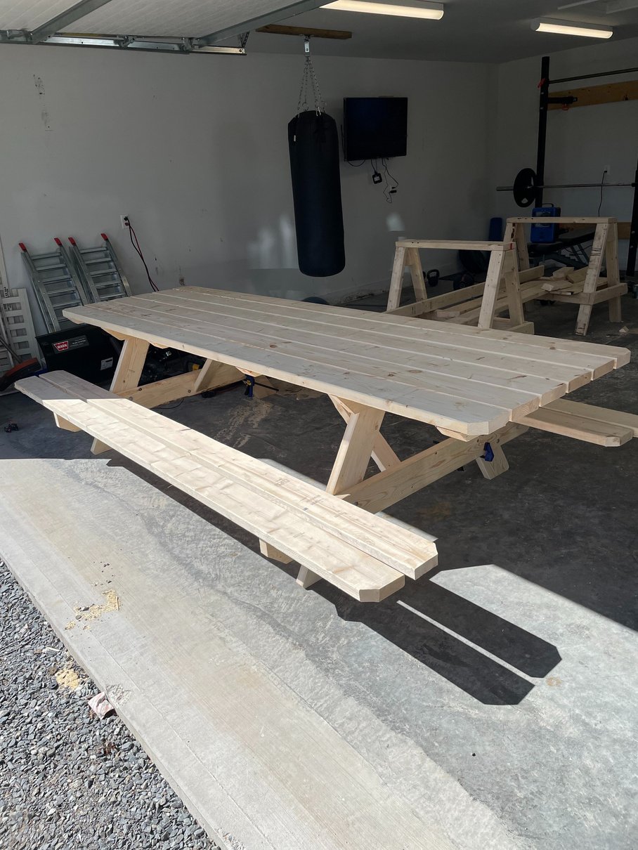 A custom built 10 Foot pine picnic table in a garage with two attached benches. 